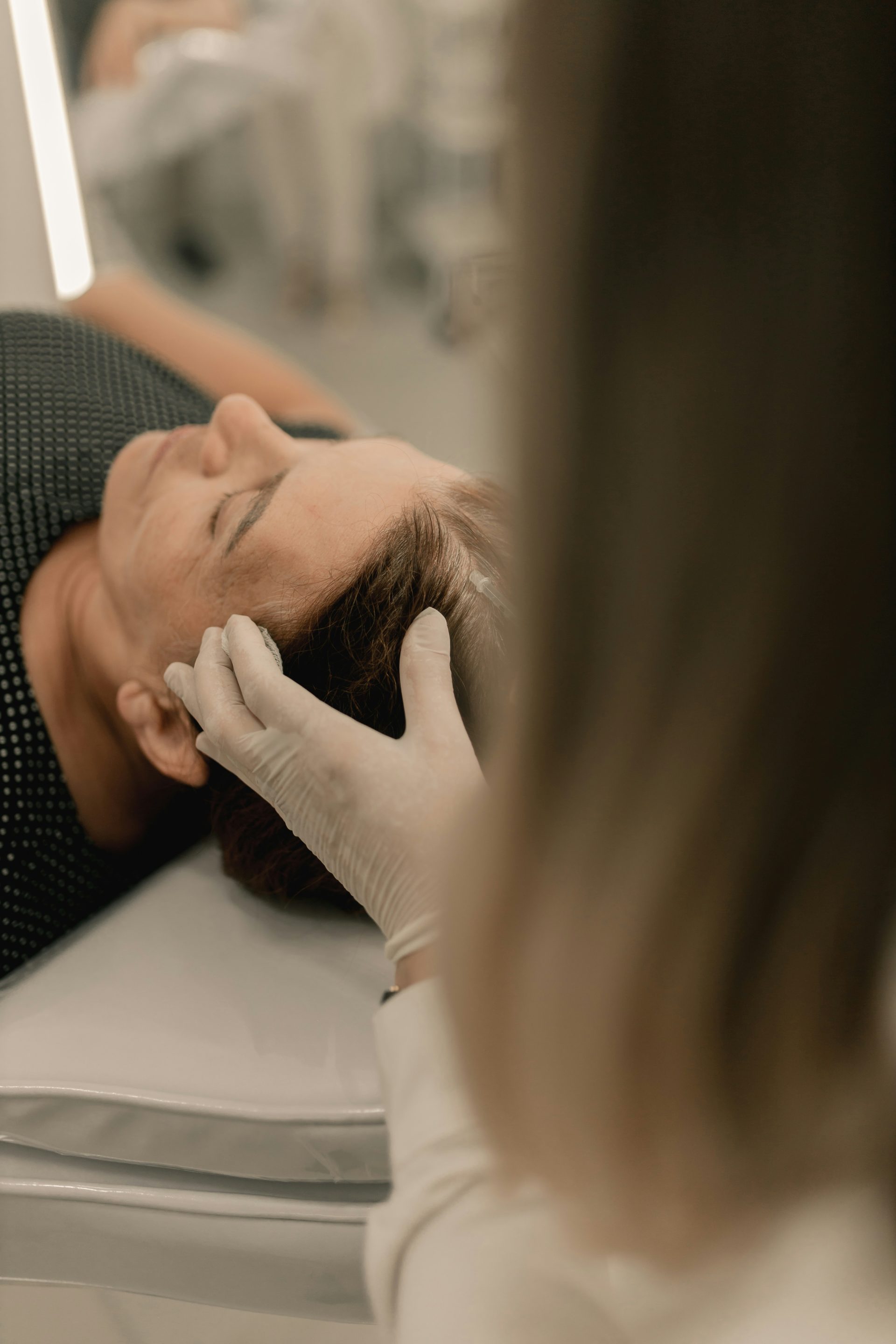 A woman getting her hair cut by a hair stylist